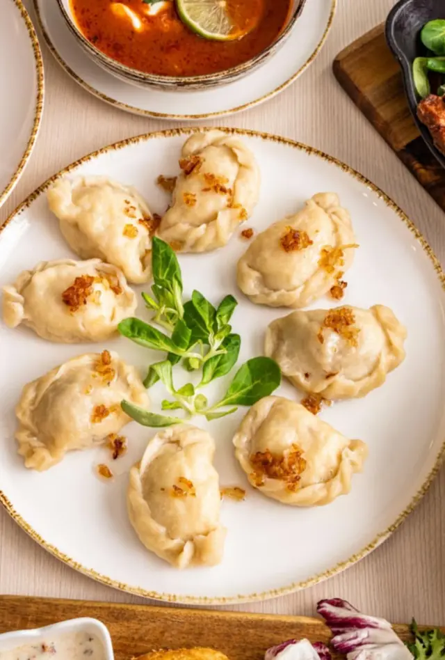 Stół z daniami Horyzontów z góry: pierogi z cebulką, naleśniki z porzeczkami, placek cygański, sałatka z łososiem i zupa